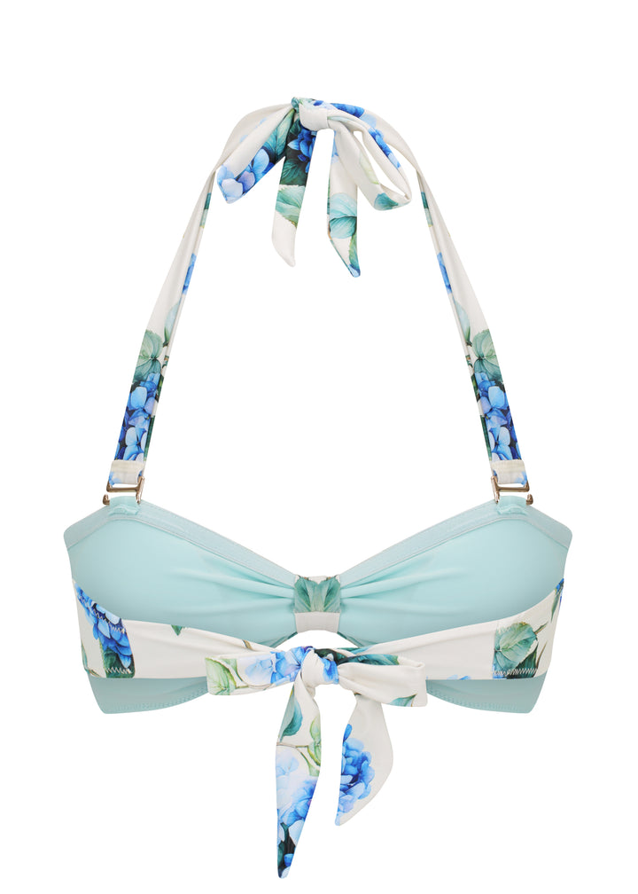 Back view of White Fleurs Duo Top in vibrant blue hydrangea floral print with green leaves, with halter neck style with ties and tie up back and a gathered center, light blue inner cloth against a white backdrop.
