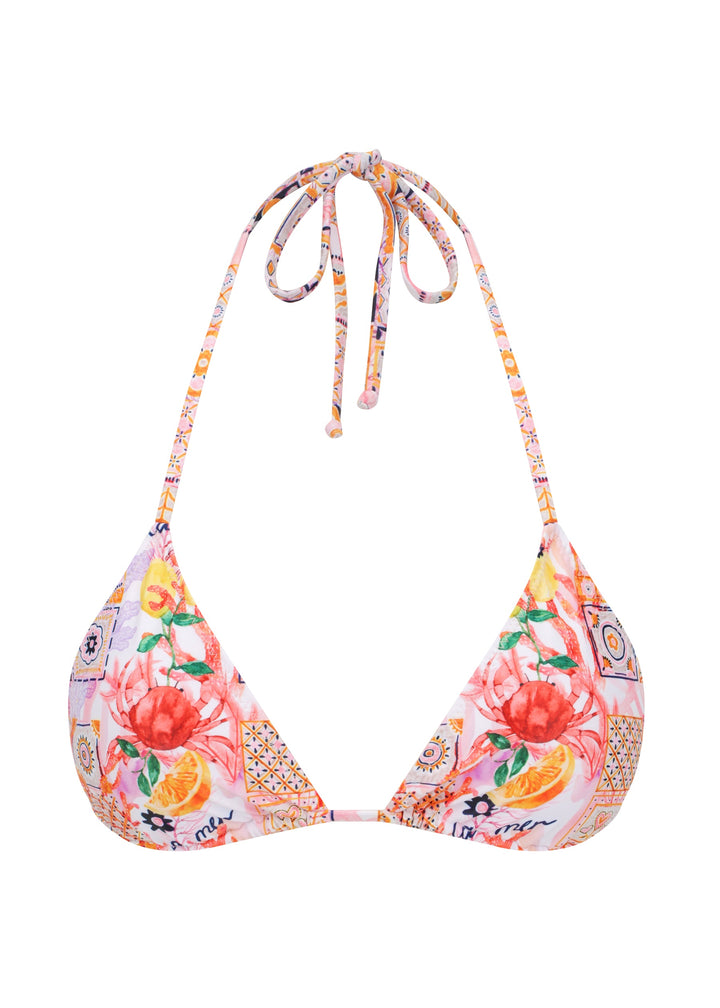 Colorful La Mer Top in classic triangle halter style with adjustable neck and back ties with a vibrant patchwork of floral and geometric patterns, including fruits, flowers, tiles, and "la mer" wordings on pink background, with removable padding, on a white backdrop. 
