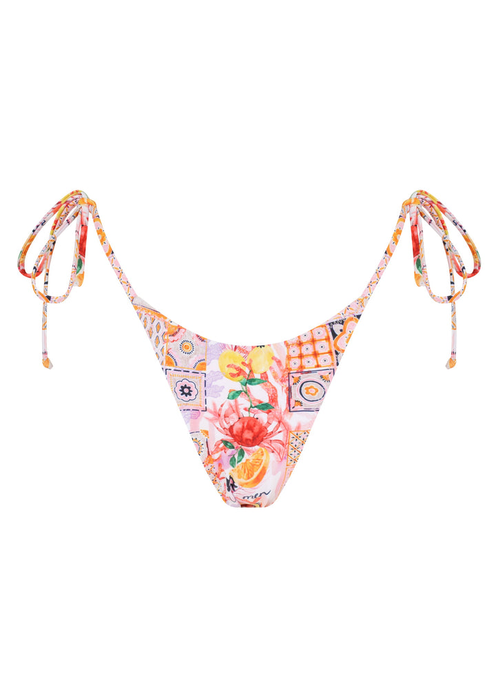 Colorful La Mer Classic Bottoms in classic triangle style with ties with a vibrant patchwork of floral and geometric patterns, including fruits, flowers, and tiles, on a white backdrop. 
