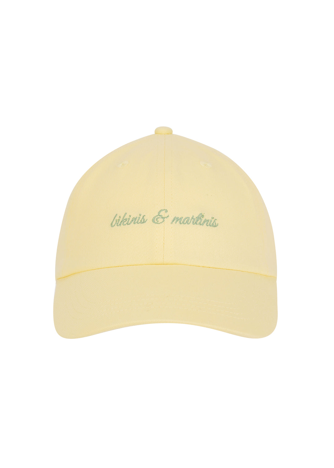 Light yellow Martini cap with the words "bikinis & martinis" in silver cursive on the front, made from 100% cotton twill, classic baseball cap design, against a white backdrop.